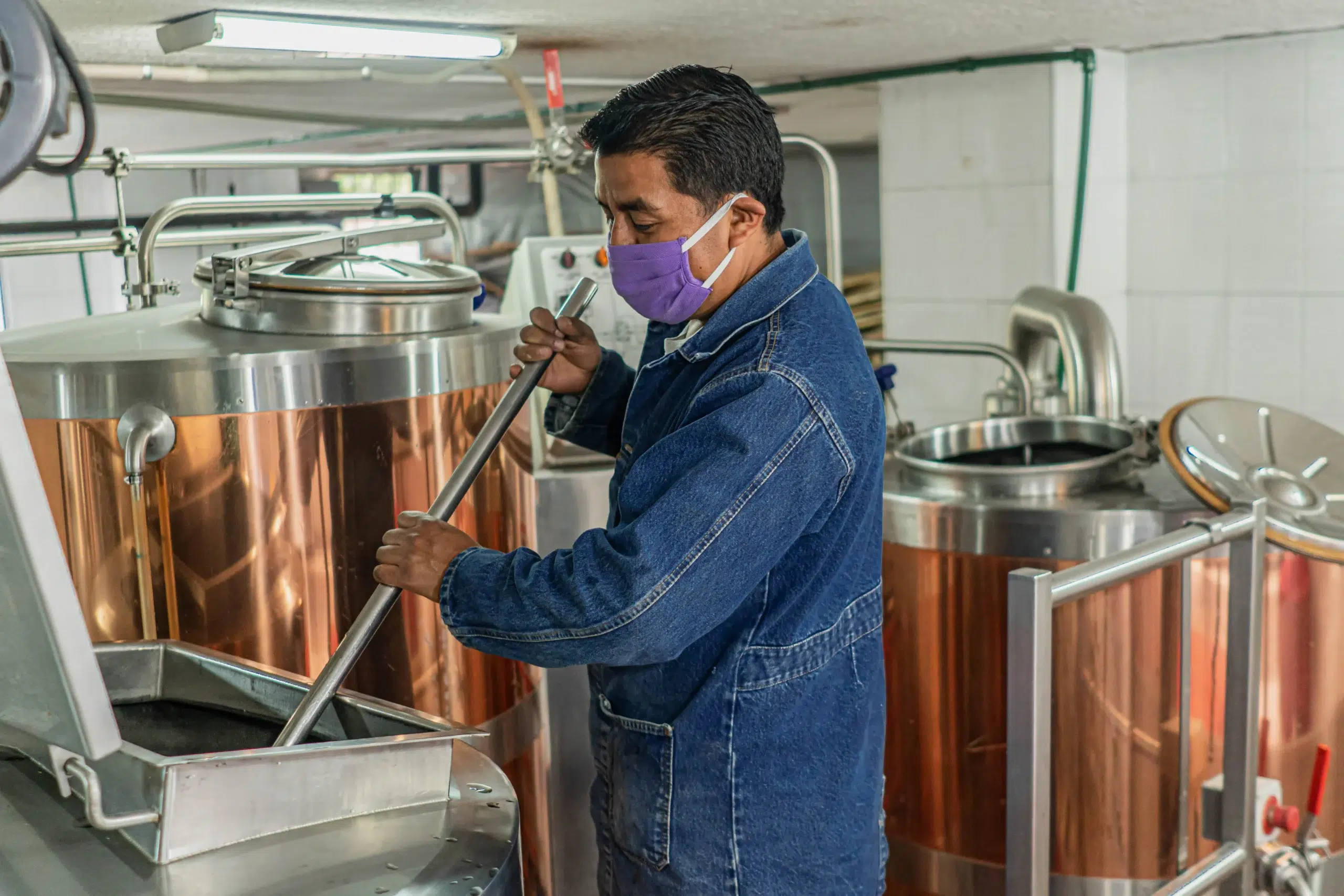 Hombre mezclando en bote de metal cervecero